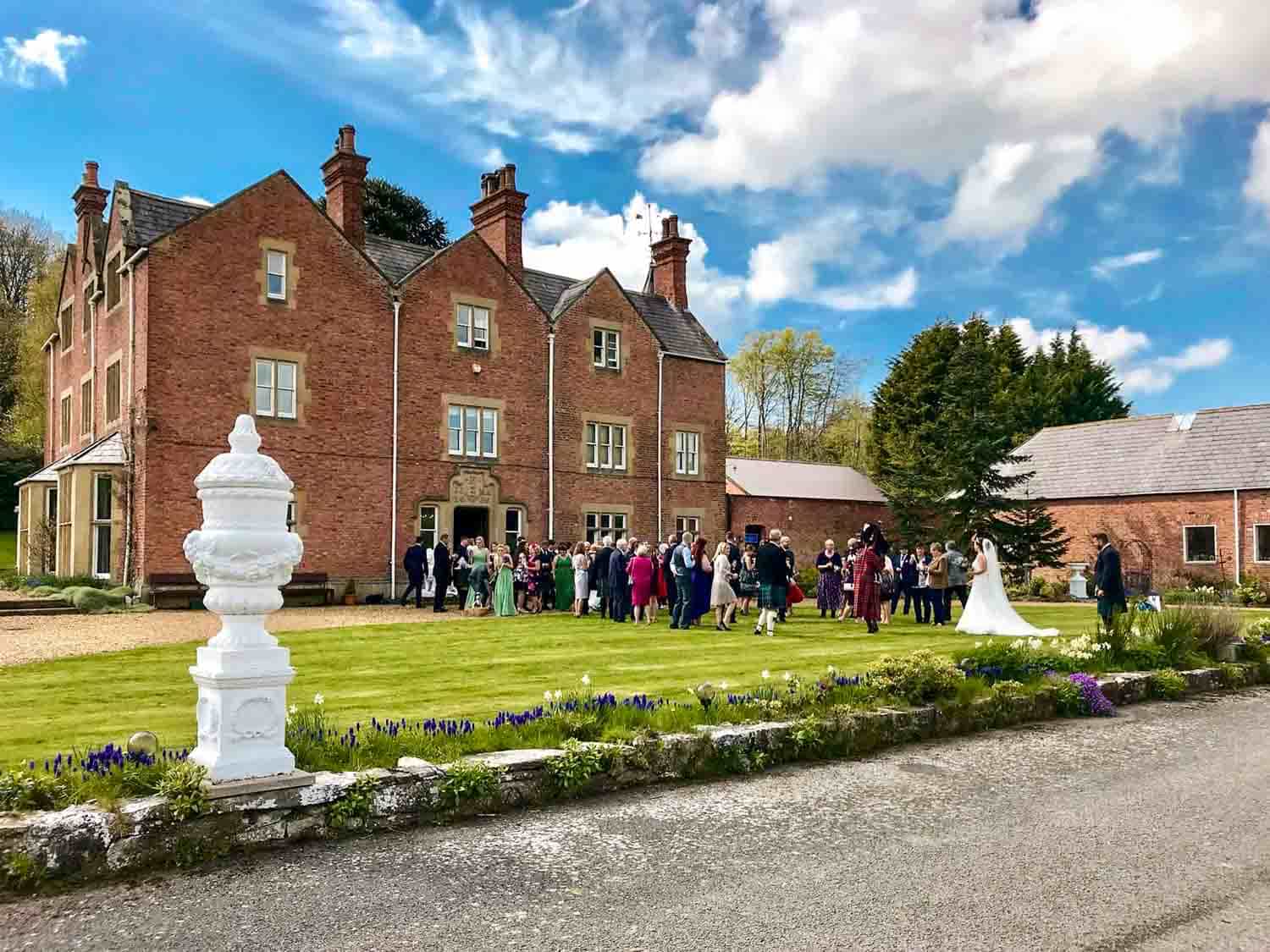 Wedding guests gather outside Henllan House